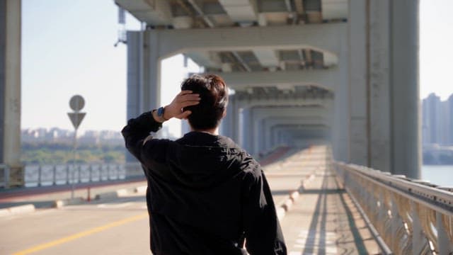 Man walking on Jamsu Bridge on a sunny day