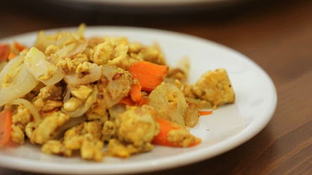 Bacon Rolls and Stir-Fried Eggs on a White Plate on the Table