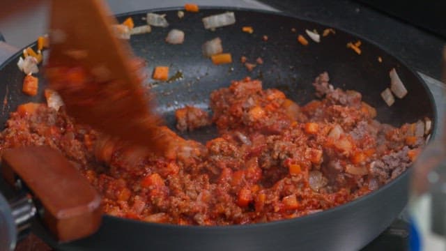 Cooking ground beef with vegetables in a pan