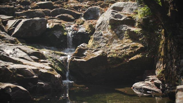 Refreshing waterfall among the sun-drenched rocks
