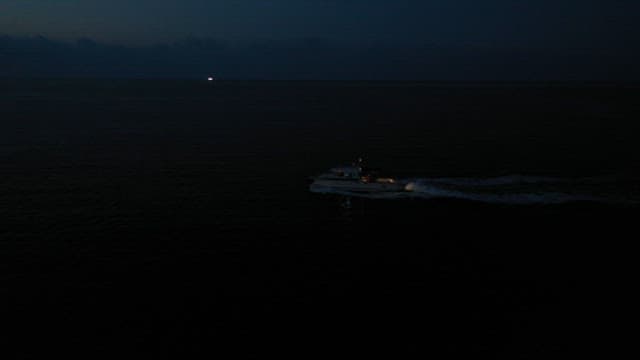 Speedboat cruising at twilight on open sea