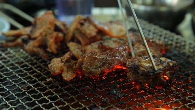 Grilling Meat Over Charcoal Flames
