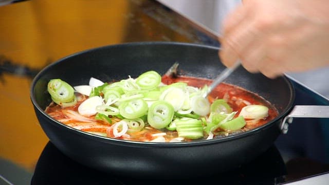 Cooking spicy stew with sand eels and green onions