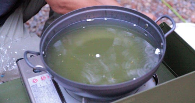 Preparing meal outdoors with a portable stove