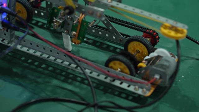Prototype robot operating on a green surface in a laboratory