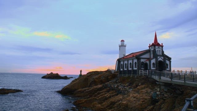 Seaside with a cathedral set with tourists in the evening
