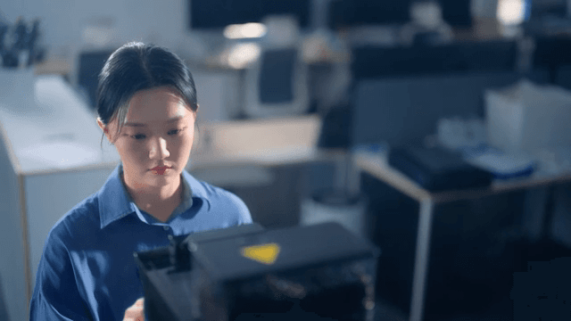 Woman using a coffee machine in an office