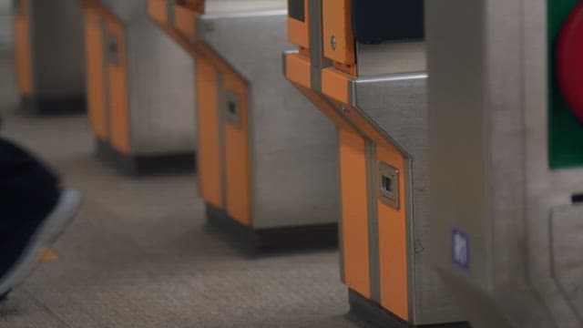 People passing through subway turnstiles