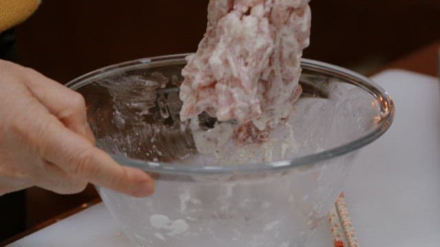 Mixing ingredients in a glass bowl inside a kitchen