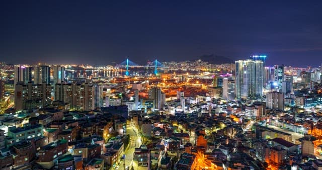 Night view of a bustling city with high-rise buildings and bright lights