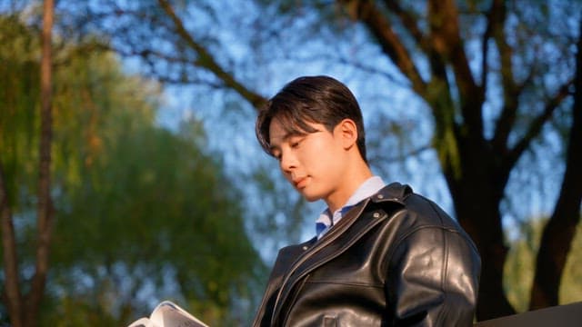 Man reading a book on a park bench