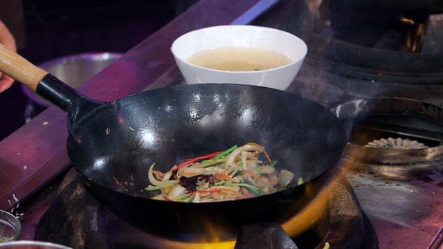Stir-frying vegetables in a hot wok