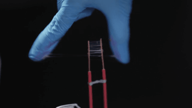 Scientist applying glue to an electrode wire while wearing gloves