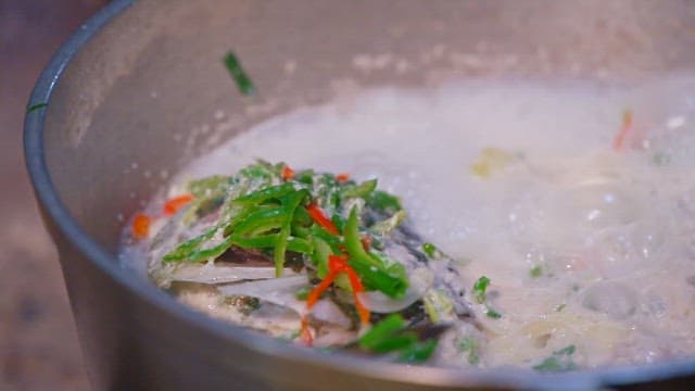 Fish curry cooking in a large pot