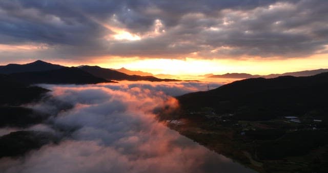 Sunrise over misty mountains and river