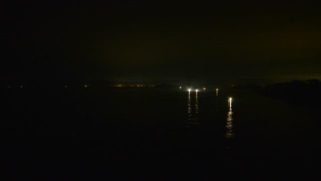 Nighttime Fishing Boat with Bright Lights on Sea