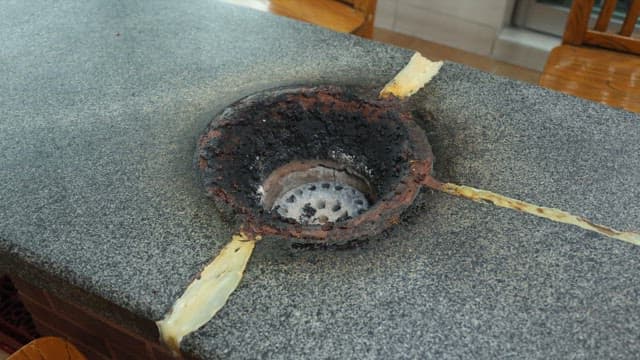 Taking out briquettes from the brazier on a stone table