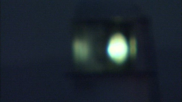 Lighthouse's light glowing faintly in the darkness