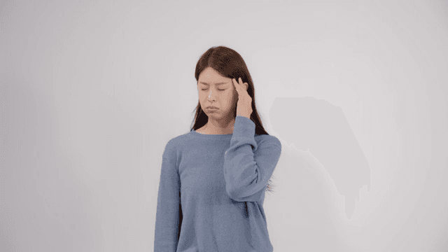 Woman holding her head with feeling headache and discomfort