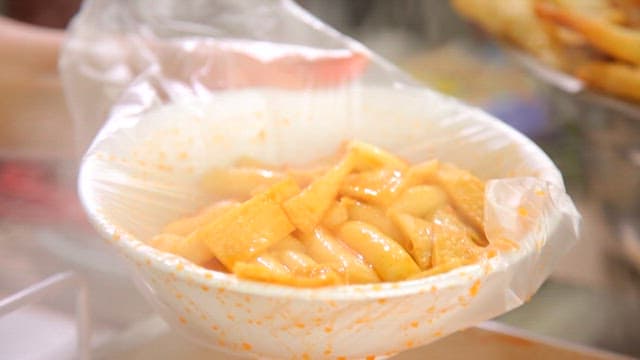 Steaming tteokbokki in a plastic-wrapped bowl