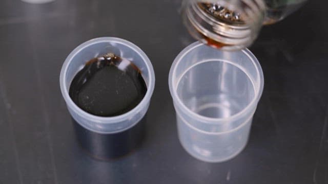 Pouring Soy Sauce into a Plastic Cup