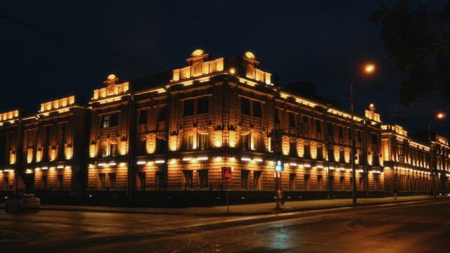 Illuminated magnificent building at night with street lamps