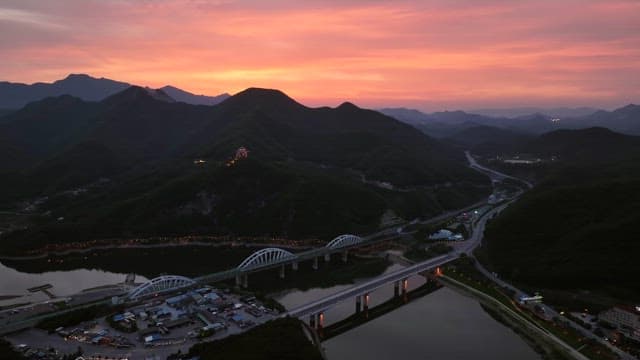 Sunset over mountains and a bridge