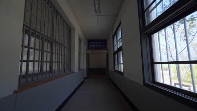 Prison Hallway with Barred Windows