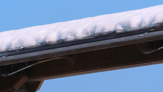 Snow-covered wooden roof on a clear day