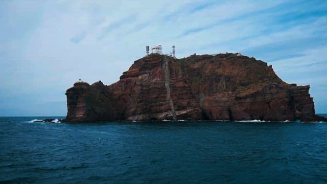 Calm Sea with Lighthouse on Cliff