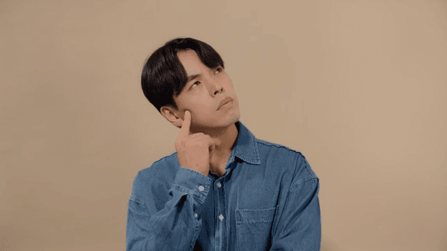 Man lost in thought, resting her finger on her chin