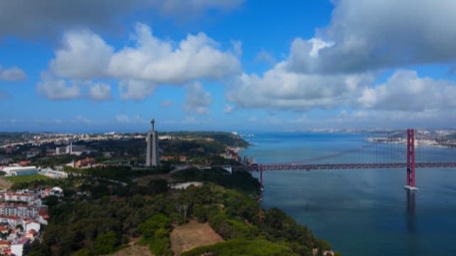 Scenery of a Tranquil River and Red Bridge Under the Blue Sky