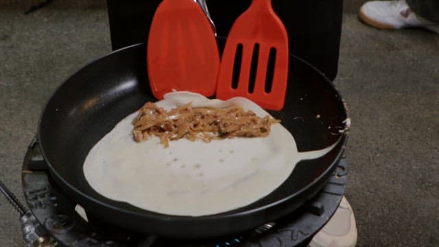 Rolling buckwheat pancakes from a frying pan using a flipper