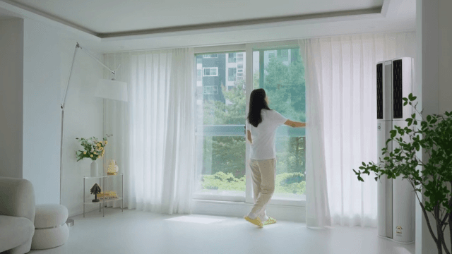 Woman opening curtains in modern living room in white interior