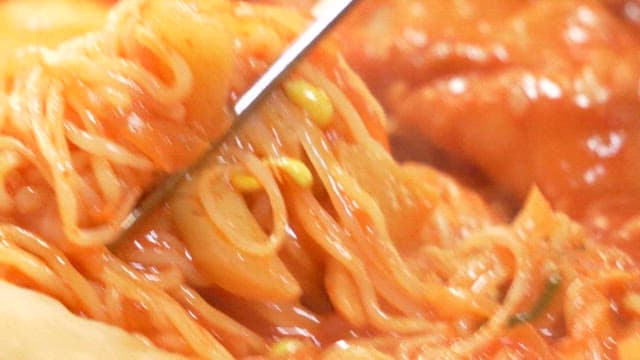 Chopstickful of spicy chewy rice cakes with jjolmyeon