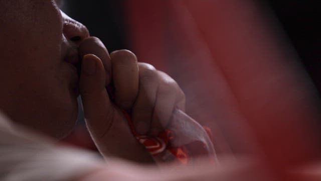 Person Coughing while Holding a Red Handkerchief