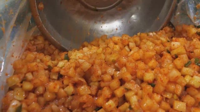 Preparing spicy diced radish kimchi with traditional seasonings