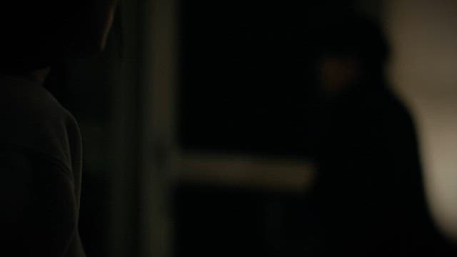 Woman Pressing 211 on Cell Phone Keypad in Dark Room