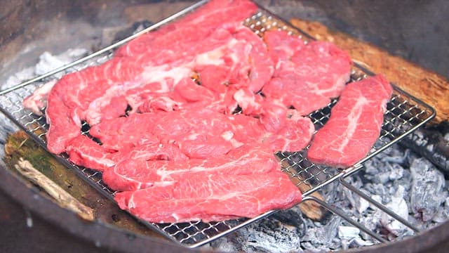 Grilling Fresh Steak on Charcoal Barbecue