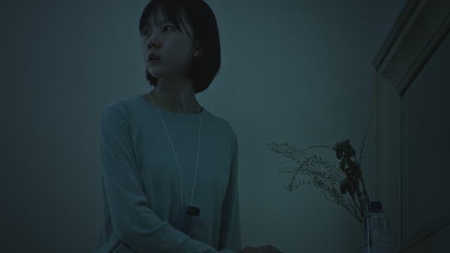 Woman trapped in a dark room with a locked door