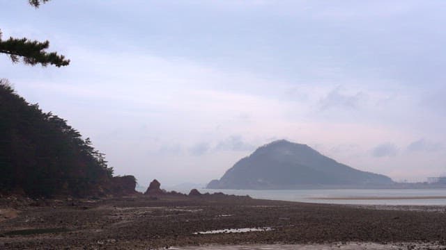 Pebble beach on a cloudy day with clouds and fog