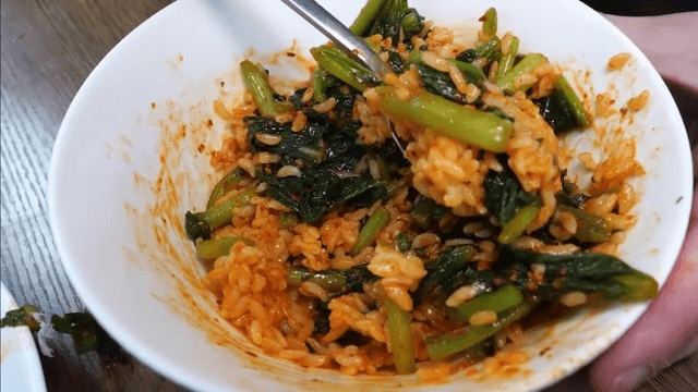 Mixing spicy young radish bibimbap in a bowl