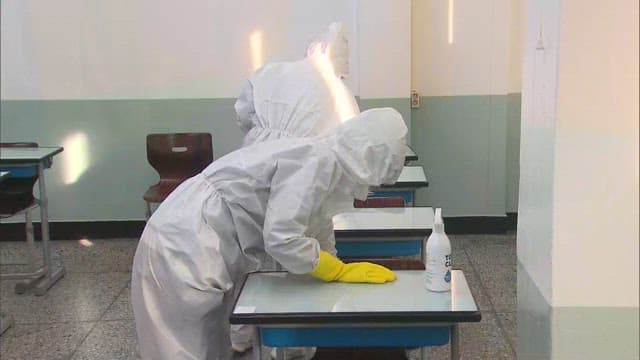 Person Sanitizing Classrooms in Protective Suit