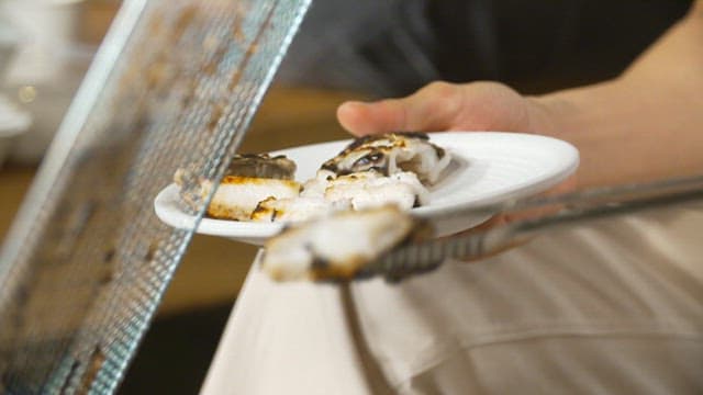 Plating sea eel grilled until golden brown on a barbecue grill