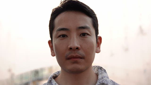 Man smiling outdoors in the evening