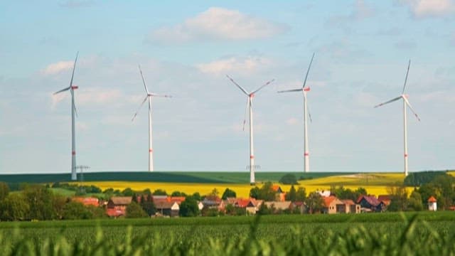 Wind turbines on green and yellow fields