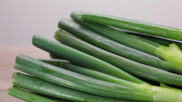 Fresh green onions on a woven basket