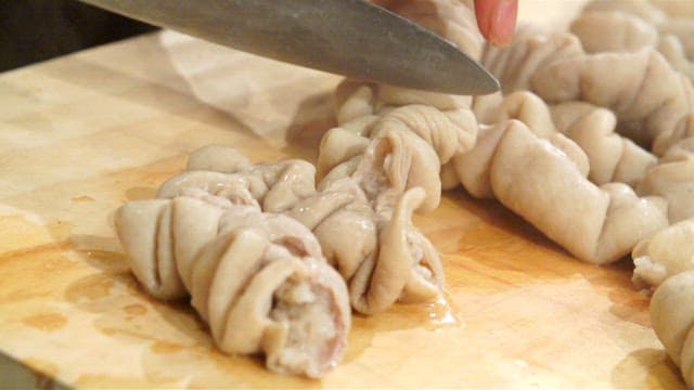 Cutting pork intestines on a wooden board