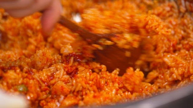 Mixing spicy julienne Korean radish salad bibimbap with a spoon