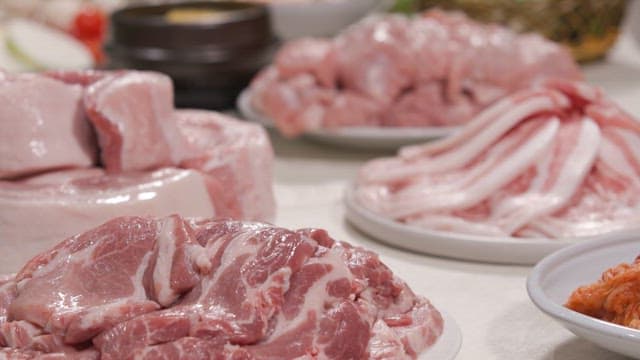 Various cuts of fresh pork on plates